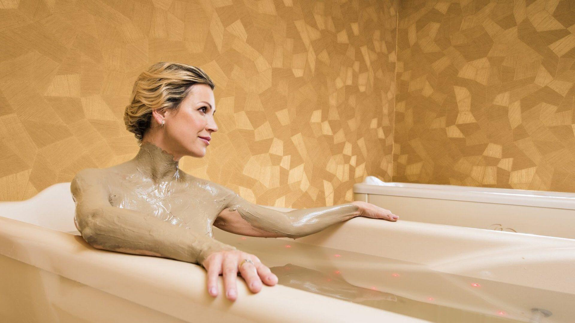 Жена купается ванне. Пелоидотерапия (грязелечение). Грязевая ванна. Лечебные ванны.